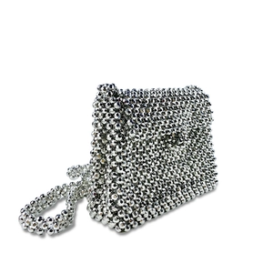 Detailed view of the shiny silver handmade woven beaded crossbody bag with flap