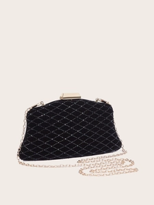 Detail of black quilted evening clutch with gold chain strap and metal clasp closure