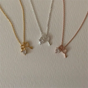 Detailed view of heart padlock and key necklaces in gold, silver, and rose gold finishes