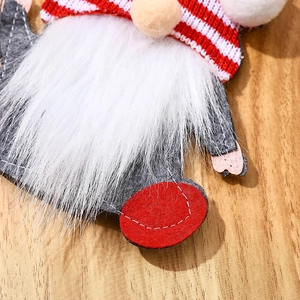 Close-up of a festive Christmas gnome cutlery holder with red striped knit hat and soft beard