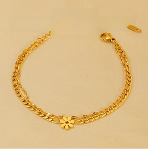 Detail of 18K gold-plated stainless steel Figaro chain bracelet with daisy charm