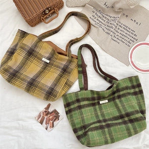 Detailed view of autumn winter plaid tweed tote bags in yellow and green with wide handles