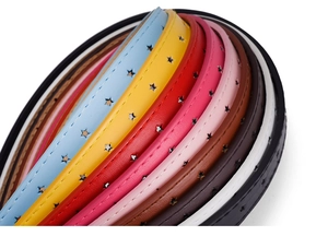 Close-up of colorful PU leather belts with hollow star patterns and fine edge stitching