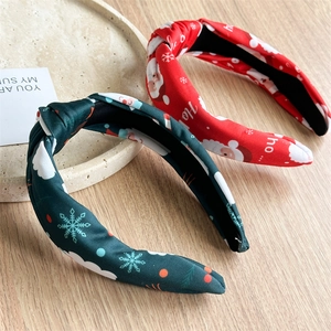 Close-up of Christmas knotted headbands with Santa Claus and snowflake prints on fabric