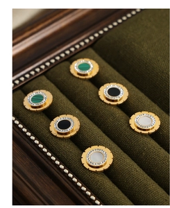 Macro detail of round gold-plated titanium earrings with malachite and zircon pavé