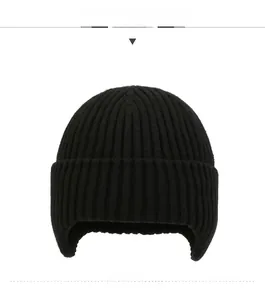 Close-up of black ribbed knit ear-protection hat featuring a stylish metal side logo