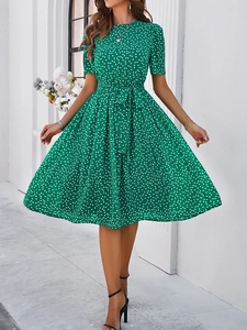 Détail de la robe midi verte à pois montrant la taille ceinturée et la coupe trapèze élégante