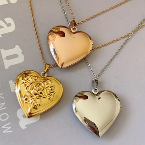Three gold, silver, and rose gold heart locket necklaces with rose floral embossing