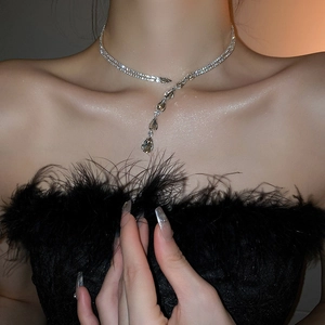Détail d'un collier ras du cou argenté à deux rangs de strass avec pendentif goutte