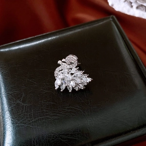 Macro detail of swan-shaped ear cuff with sparkling zircons on black leather gift box
