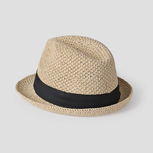 Close-up of beige woven straw fedora featuring a wide black ribbon and texture detail