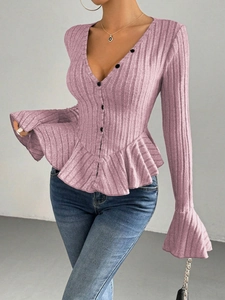 Close-up of pink V-neck knit top showing ruffle cuffs and delicate ribbed texture