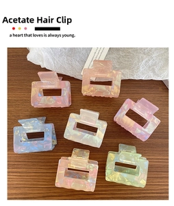 Macro shot of assorted colorful acetate rectangular hair claws on a wood surface