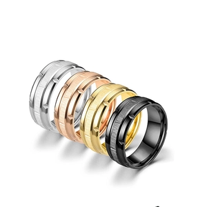 Detailed view of four textured titanium steel rings in silver, gold, rose gold, and black