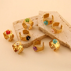 Set of eight gold wide hammered open rings with colorful flower bead decorations