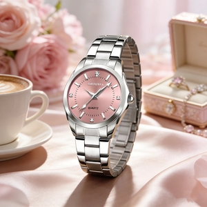 Detail of pink dial quartz watch with silver steel strap on elegant pink silk cloth