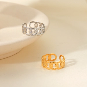 Detailed view of hollow chain link rings in gold and silver finish on a ceramic plate