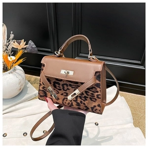 Detail view of the brown leather and leopard print patchwork texture on the handbag
