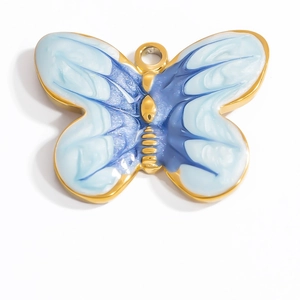 Macro detail of butterfly pendant with blue enamel inlay and 18K gold plated steel edges