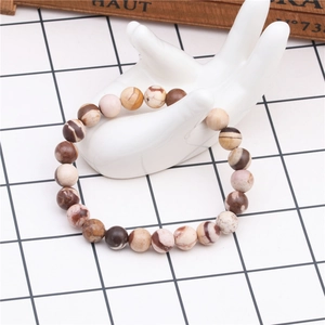 Detail view of 8mm tiger eye stone beaded bracelet on a white ceramic hand model