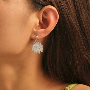 Silver sunflower drop earrings in minimalist style shown on a model for a stylish look