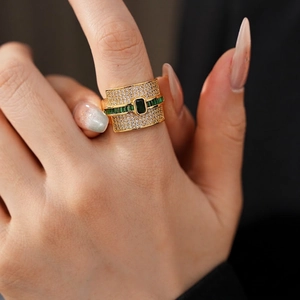 Luxury gold wide ring featuring emerald-cut green zircon and pave crystals on hand