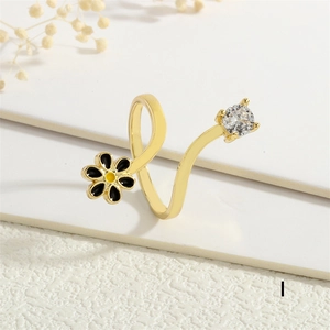 Detailed close-up of a golden daisy ring with enamel petals and a sparkling zircon stone