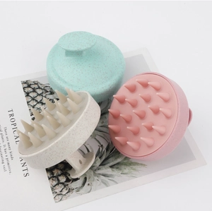 Three scalp massager brushes in mint green, beige, and pink with flexible silicone teeth