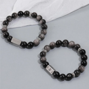Obsidian beaded bracelets with titanium steel Forever plaque on a light gray background