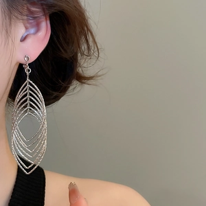 Close-up of elegant silver layered leaf earrings worn by a model in soft lighting