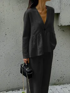 Detail view of black V-neck long sleeve top with ruffle hem and matching trousers set