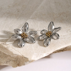 Detailed view of bicolor flower earrings with silver petals and golden center on stone