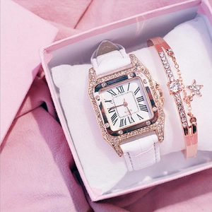 Detail of square gold diamond watch and star pendant bracelet in a pink luxury gift box
