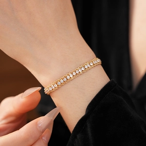 Detailed macro view of a luxury three-row gold chain bracelet with sparkling round zircons