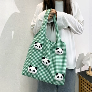 Detail view of large canvas tote bag featuring green checkered pattern and plush panda toys