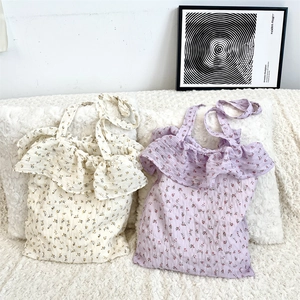 Detail of floral chiffon tote bags with ruffled edges in cream and lavender purple
