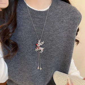 Close-up of silver deer necklace with sparkling rhinestones and snowflake tassels on a model