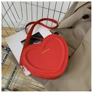 Dettaglio della borsa a tracolla in pelle rossa a forma di cuore in un carrello