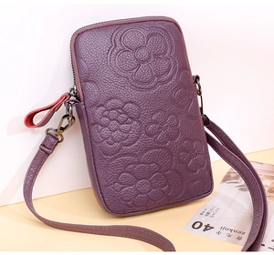 Détail d'un sac bandoulière violet avec motifs floraux gaufrés et fermeture éclair en métal