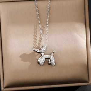 Detailed close-up of a silver balloon dog pendant with white zircons in a jewelry box