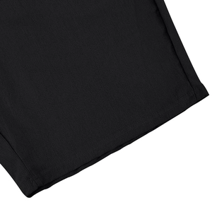 Close-up of flat-seam stitching on black linen fabric for men's summer polo and shorts set