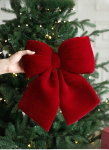 Large red velvet bow decoration for Christmas tree ornaments and festive holiday window displays