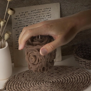 Detailed rose flower candle with realistic petals, held to show scale and texture