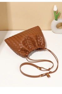 Detailansicht der braunen geflochtenen Ledertasche mit schicken Raffungen und Riemen.