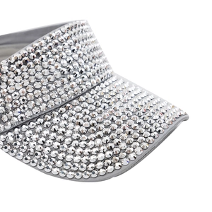 Close-up of sparkling rhinestones on the silver-grey fabric brim of a sun visor hat