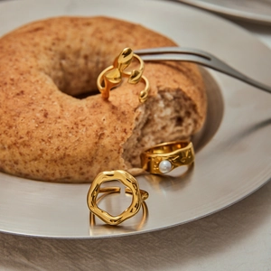 Chic gold-plated stainless steel ring set with white pearl displayed on a metal tray