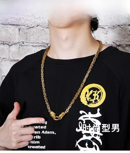Detail of golden Byzantine chain necklace featuring ornate dragon head clasps for men
