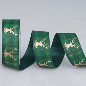 Detailed close-up of dark green plaid Christmas ribbon with gold reindeer foil print