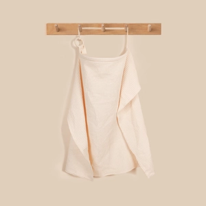 Detailed texture of cream waffle cotton nursing cover with natural wood ring attachment