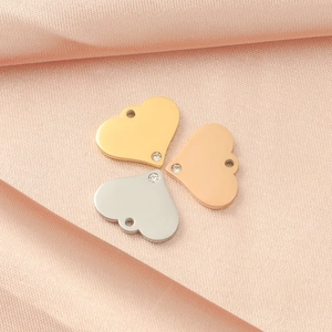 Detailed view of heart-shaped metal pendants in gold, silver, and rose gold with rhinestones